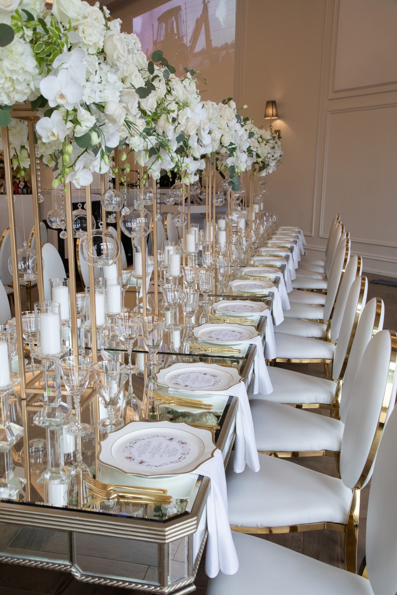 Elegant white and gold table setting with tall centrepieces