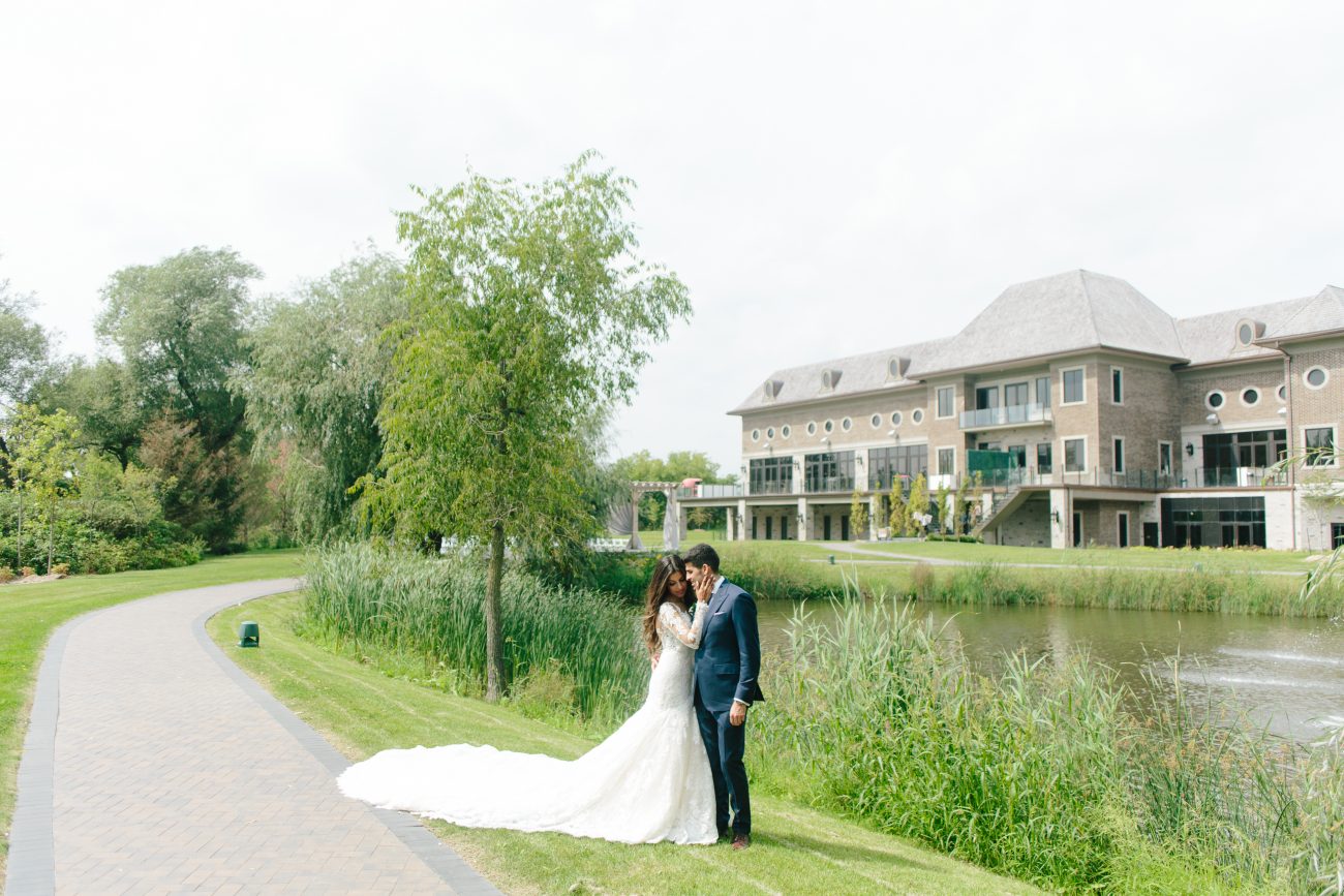 Newlyweds posing by the pond at the Arlington Estate