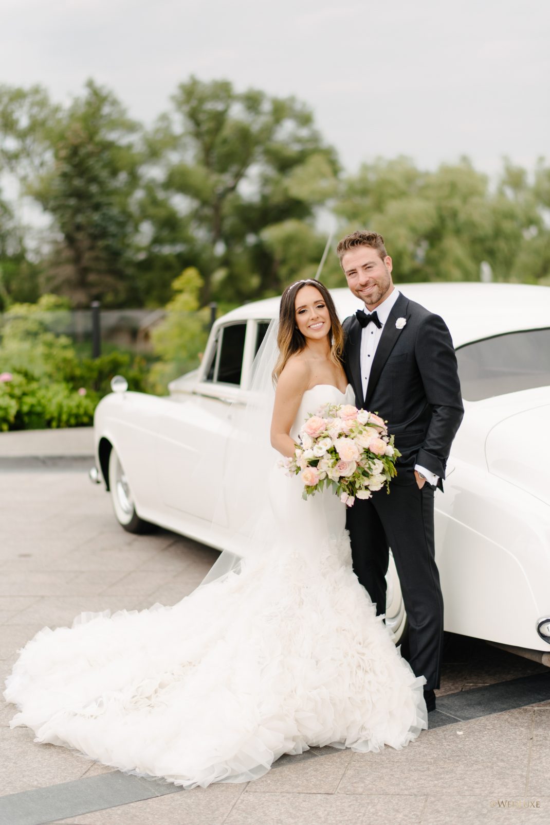 Happy Newlyweds outside with limo